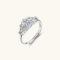 Sterling silver ring with oval moissanite center stone surrounded by smaller accent stones in ornate setting